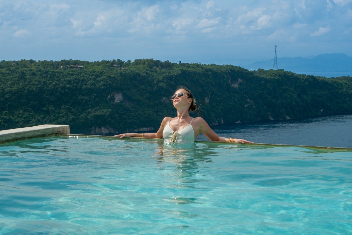 A guest in the infinity pool with an open ocean view at Amok Sun & Cliff Club, Nusa Penida