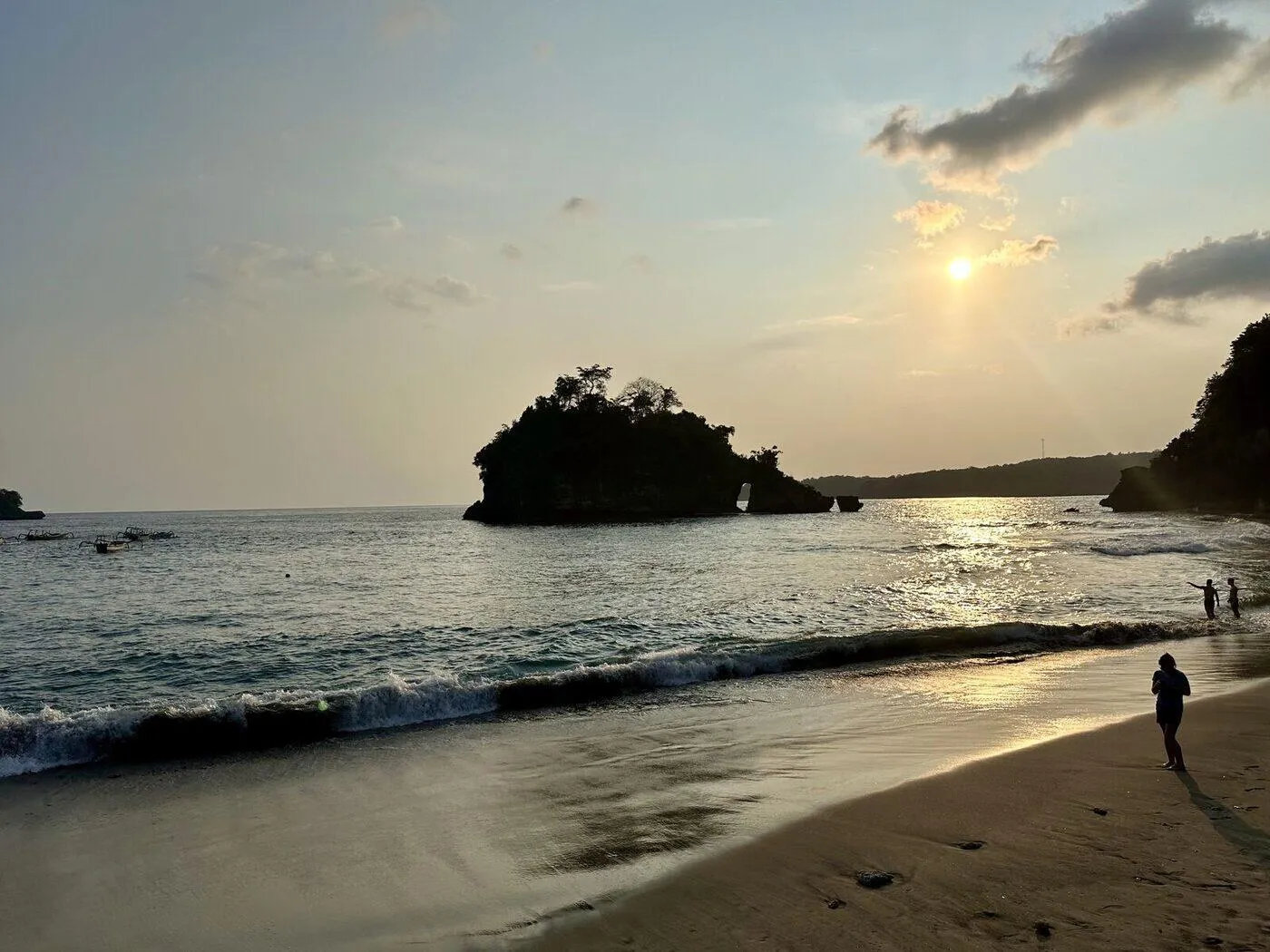 Sunset over the rock island at Crystal Bay Nusa Penida, with the sun low on the horizon and warm light over the bay