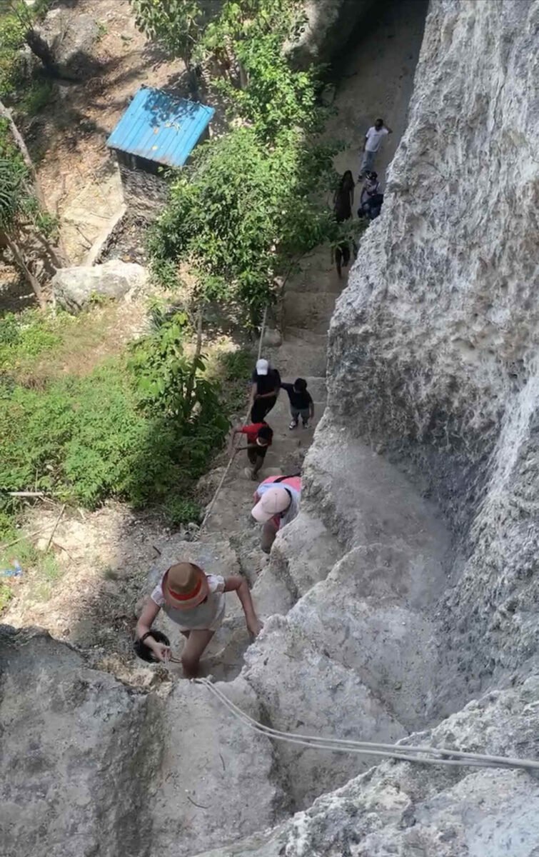 Pengunjung mendaki bagian tali yang curam di tangga Diamond Beach, Nusa Penida