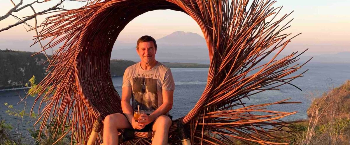Blaise Jaeger at Amok Sunset on Nusa Penida, with a view over the sea and Mount Agung in Bali