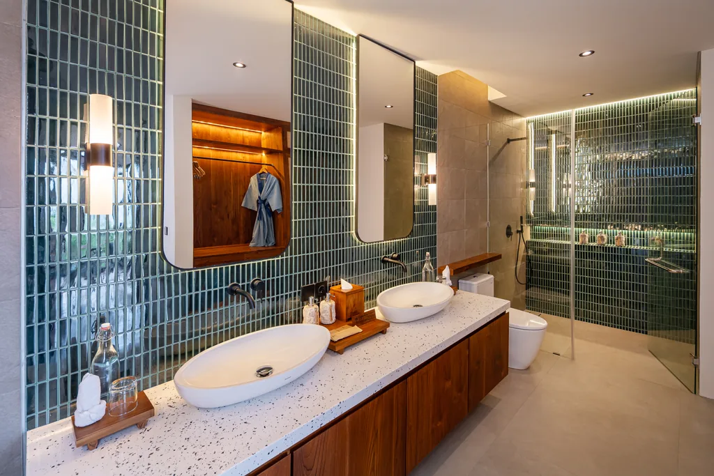 Baño con azulejos verdes, doble lavabo y ducha de obra en una villa con piscina privada de Adiwana Warnakali, Nusa Penida