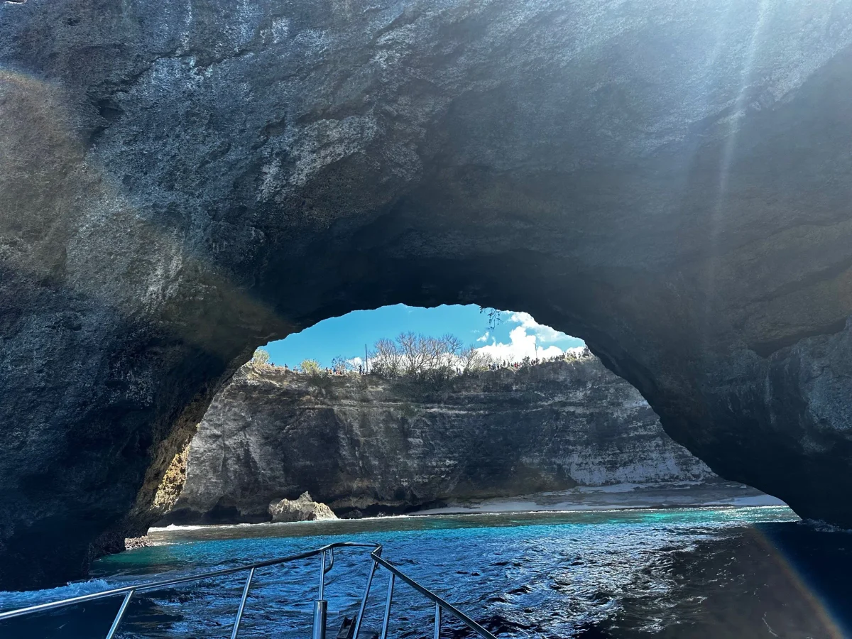 Looking through the Broken Beach tunnel from a boat toward the strip of sand inside the bay, Nusa Penida