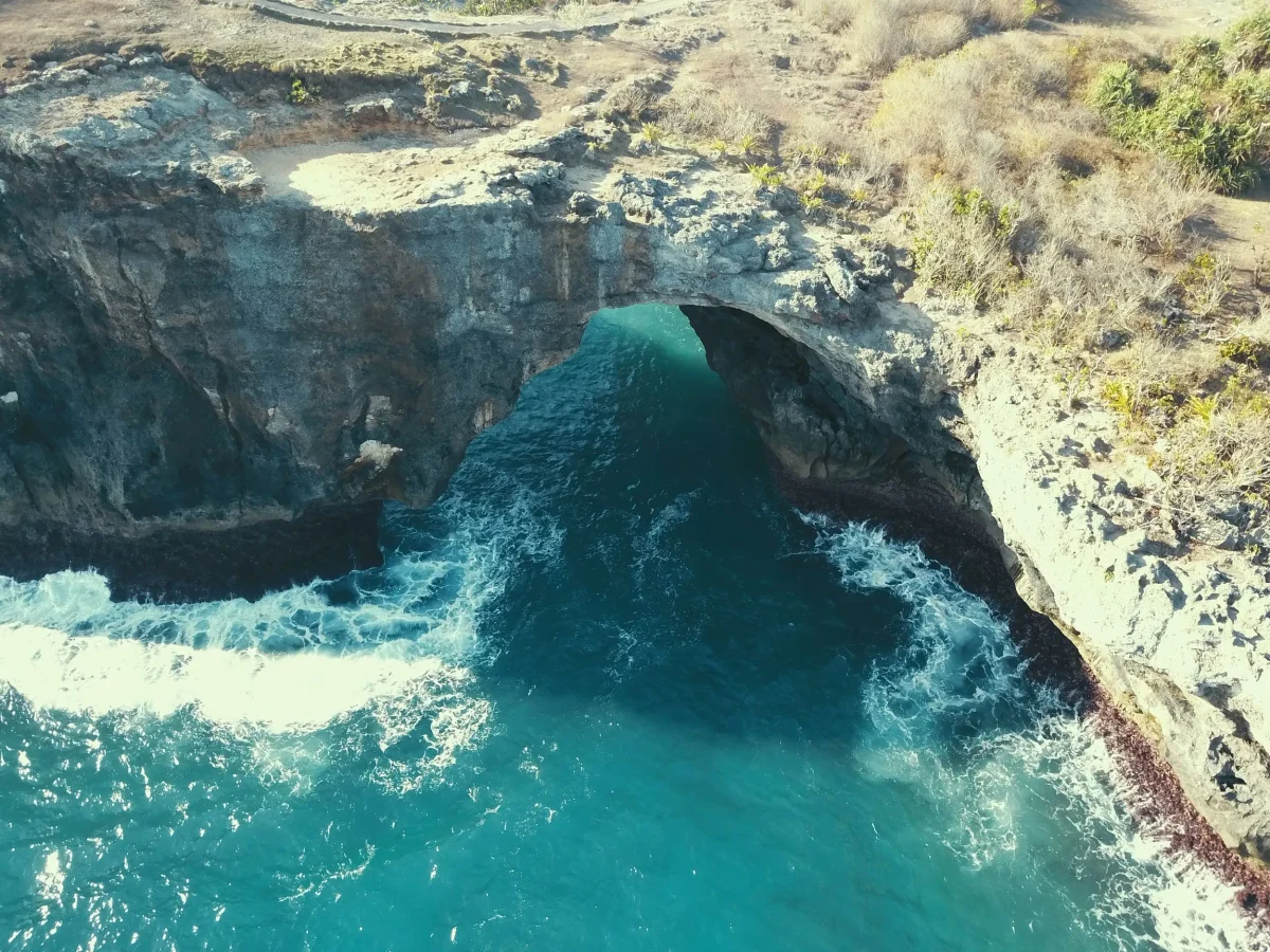 The Broken Beach arch and cliffs from the seaward side with heavy swell, Nusa Penida