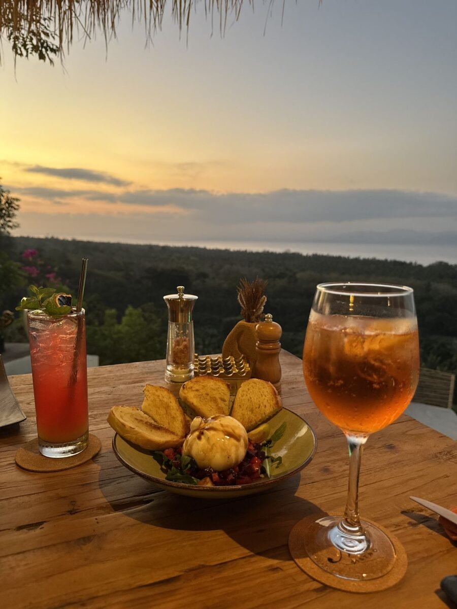 Minuman aperitif saat matahari terbenam di teras M Bistro di perbukitan Ped, Nusa Penida