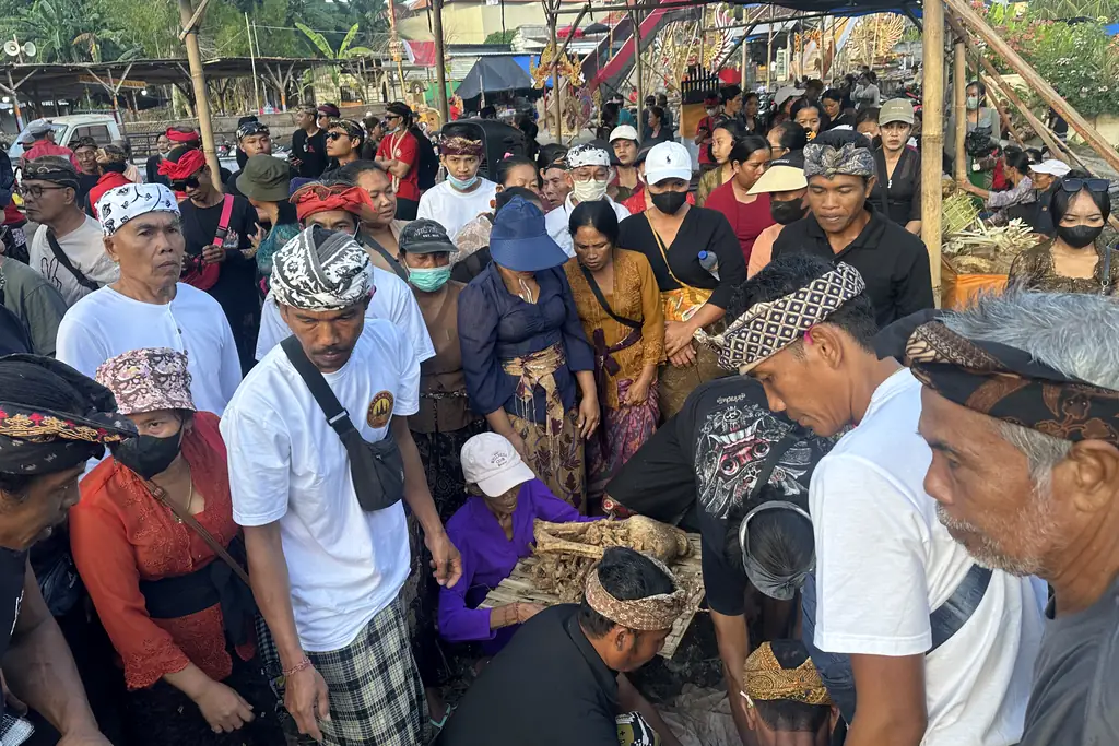 Family members gathered around the recovered bones during a Ngaben exhumation in Sebunibus