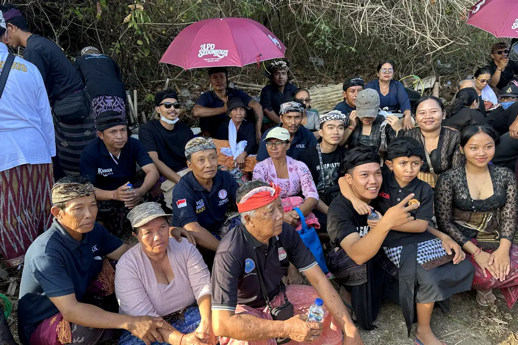 Family members waiting together during the Sebunibus Ngaben preparations