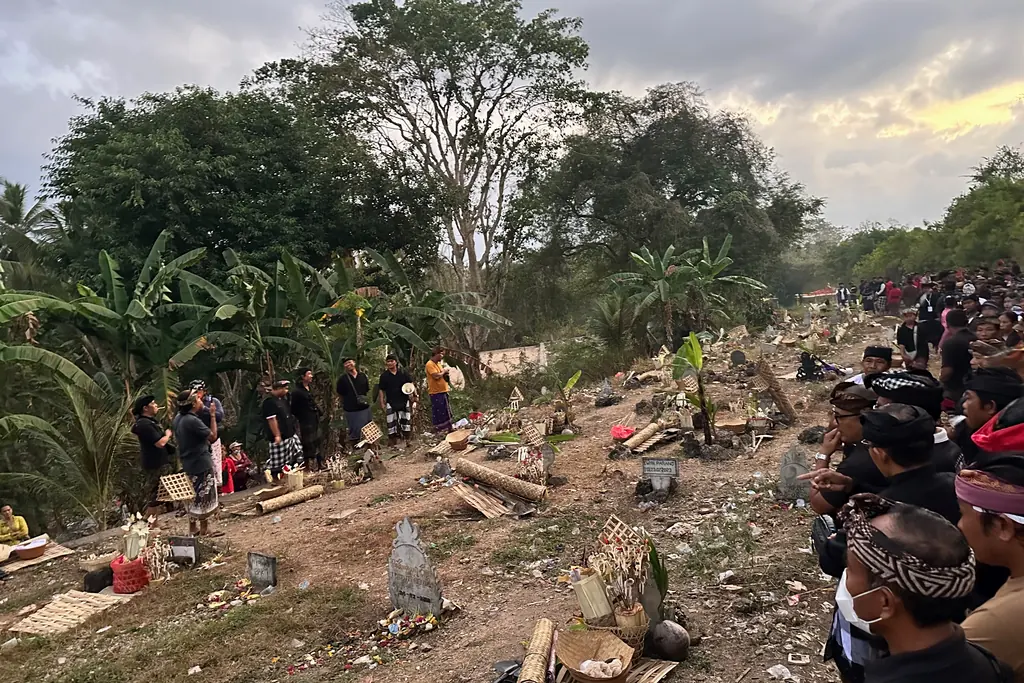 Families gathered around graves at Sebunibus cemetery before the exhumations begin
