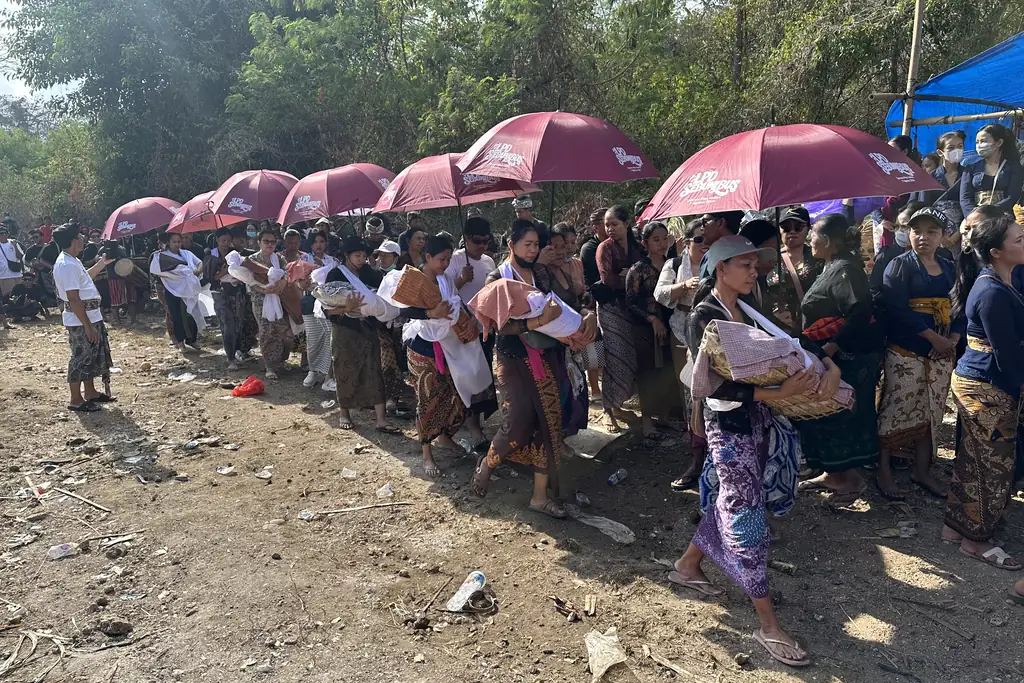 Families forming a procession while carrying the remains of their deceased relatives
