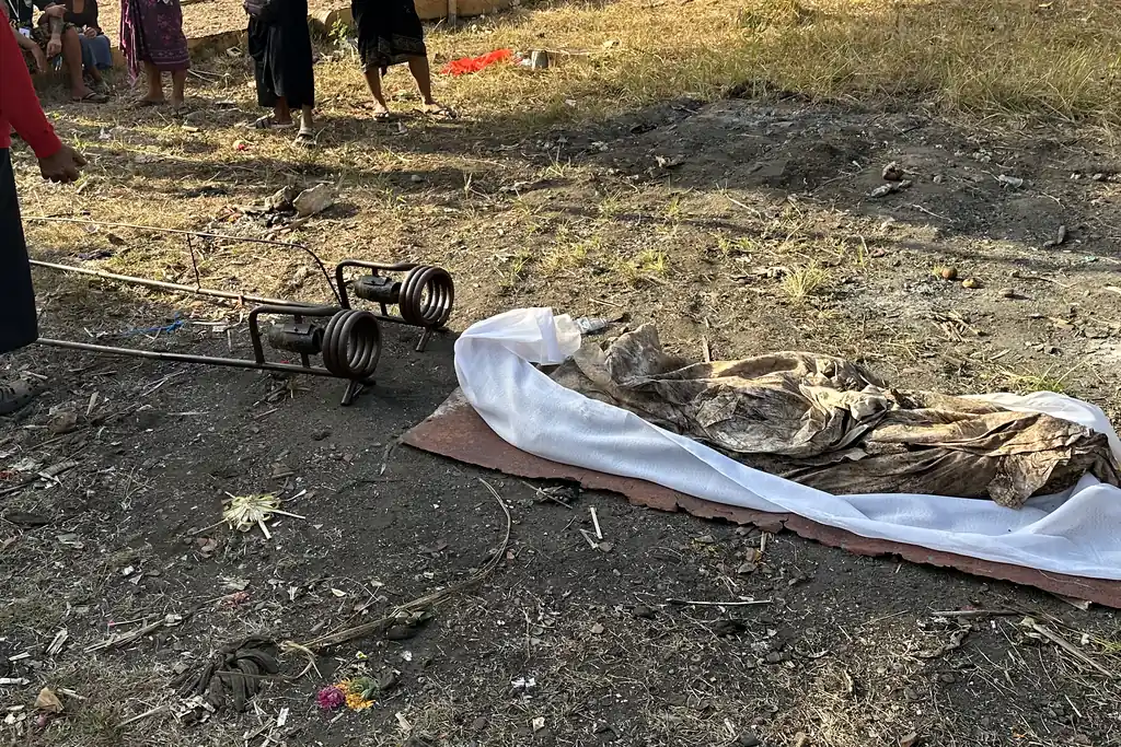 Shrouded remains prepared for a separate cremation beside Sebunibus cemetery